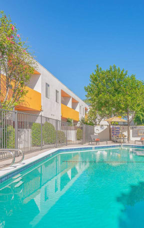 a swimming pool in front of an apartment building with a pool at The Flats on Addison, California, 91423