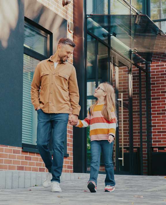 A man and a woman are walking together on a sidewalk.