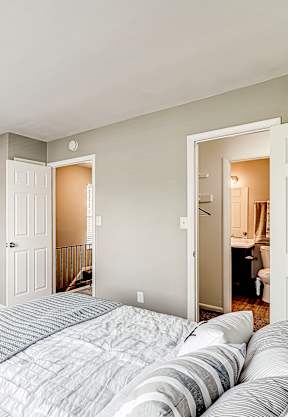 A bedroom with a large bed and a lamp on a tripod.