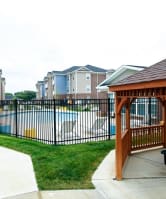a gazebo with a pool and apartment buildings