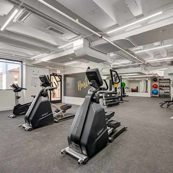 A gym with treadmills, elliptical machines, and other exercise equipment.