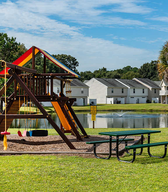 A playground with a slide and a picnic table at The Islands in Charleston SC