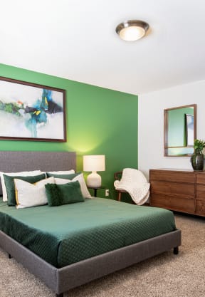 a bedroom with a green accent wall  at Preserve West, Madison, Wisconsin
