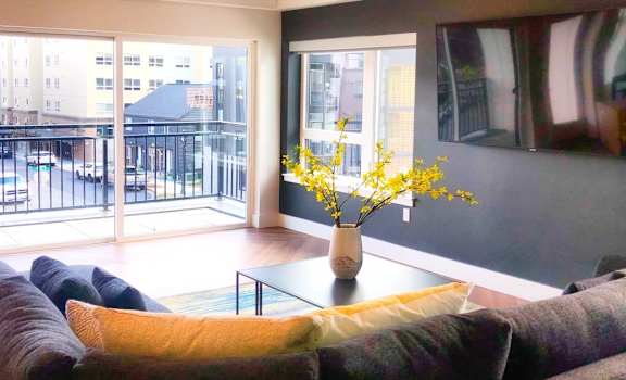a living room with a couch and a table   and a balcony