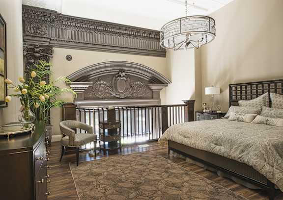 a bedroom with a bed and a chandelier at The Knights @ 506 Delaware Apartments, New York 14202