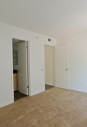 an empty living room with white walls and a carpeted floor