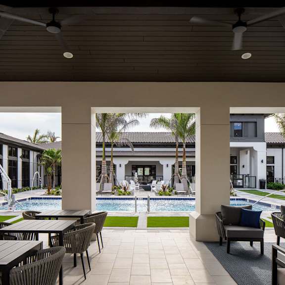 A patio with a table and chairs overlooking a pool at Las Palmas Apartments, Florida 33913