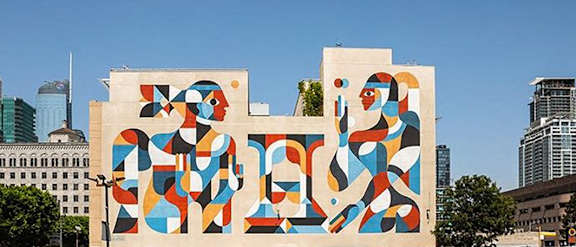A large, colorful mural on a building in a city.