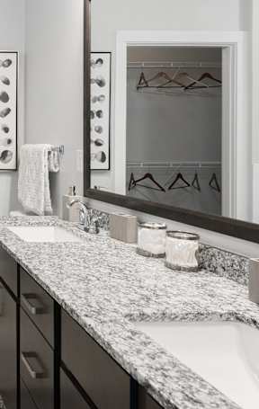A bathroom with a walk-in shower, a toilet, a sink, and a mirror.