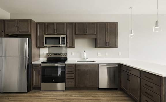 A kitchen with brown cabinets and stainless steel appliances.