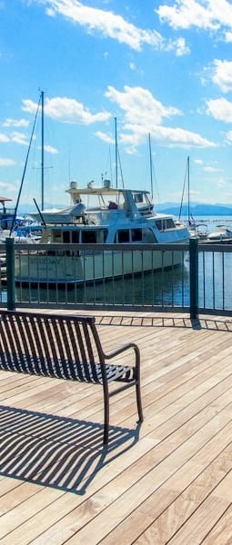 a bench on a dock overlooking a harbor with boats
