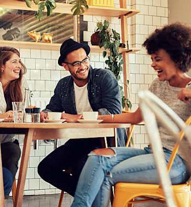 a group of people sitting around a table in a restaurant
