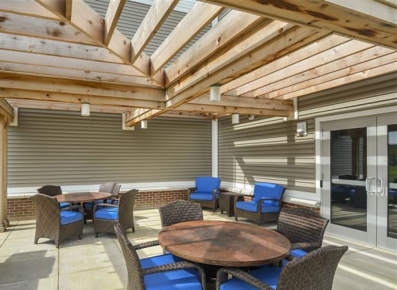 a covered patio with a grill and tables