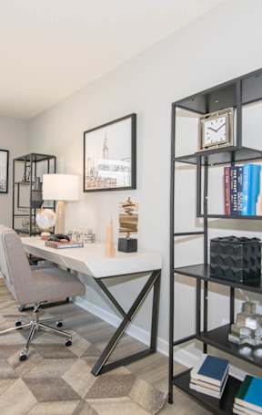A room with a desk, a chair, and a bookshelf.