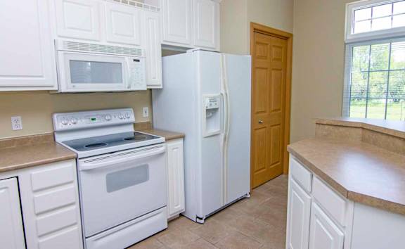 a kitchen with white appliances and white cabinets