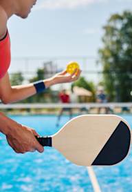 A woman is playing tennis in a pool.
