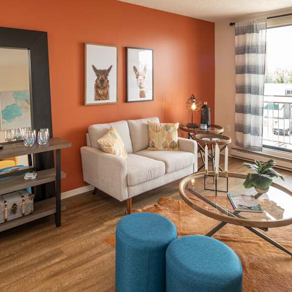 A living room with a grey couch, a round table, and a television.
