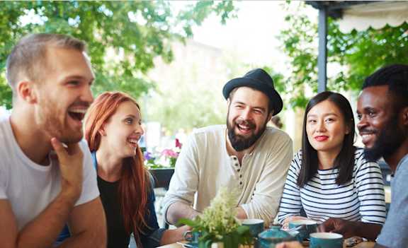 a group of people sitting around a table talking