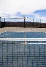 A tennis court with a net and a fence.