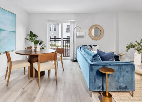 a dining and living room with a blue couch