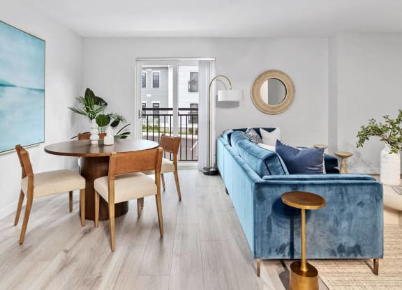 a dining and living room with a blue couch