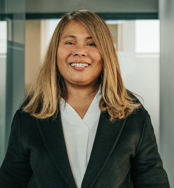 a woman wearing a suit and smiling in an office