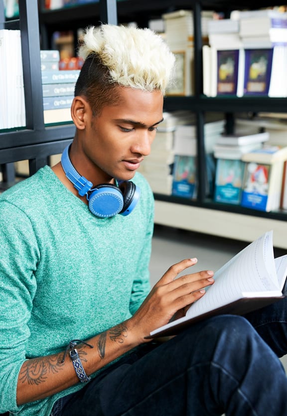 this is a photo of a young man reading at the local bookstore.