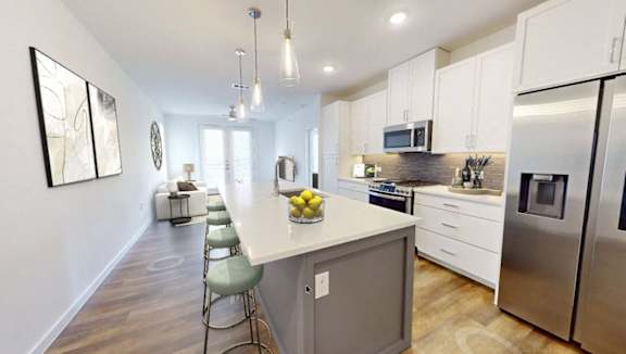 A modern kitchen with stainless steel appliances and white cabinets.