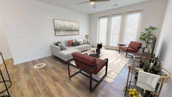 A living room with a sofa, chairs, and a plant.