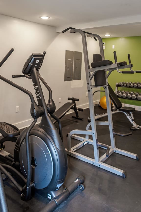 a gym with exercise equipment on the floor and green walls