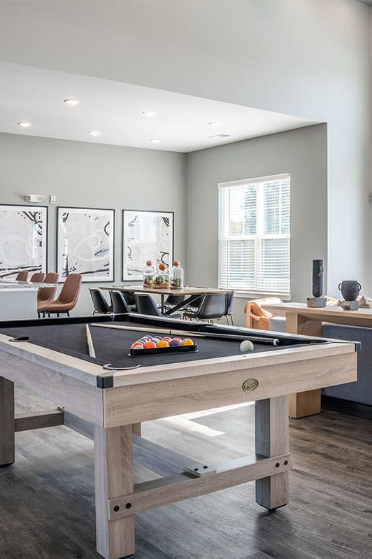 a living room with a pool table and a fireplace