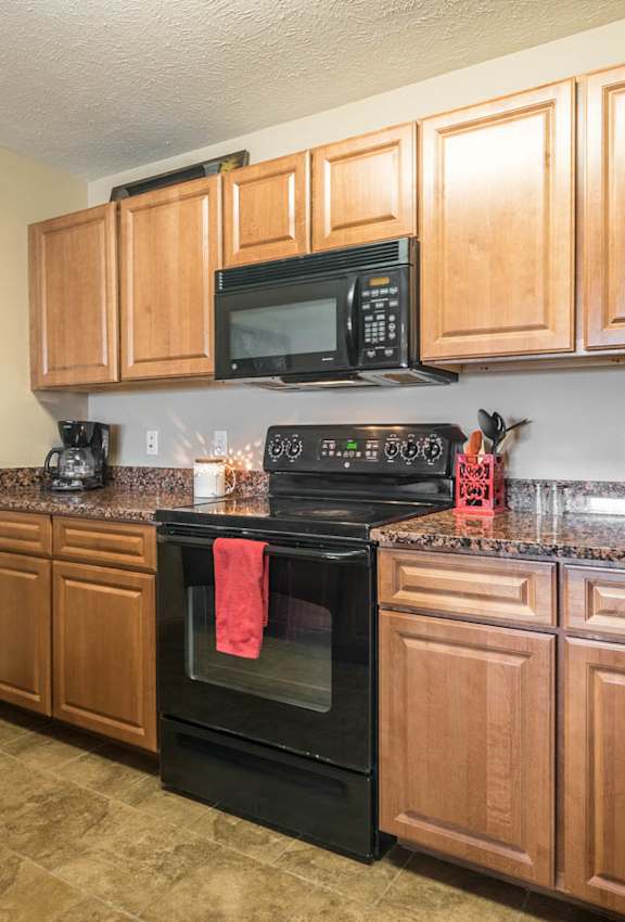 a kitchen with black appliances and wooden cabinets