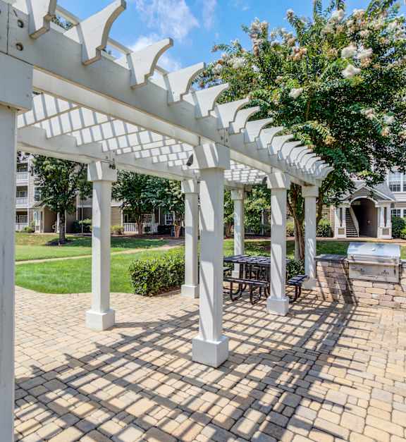 a patio with a barbecue grill and a stone wall and a pergola at Marina Point, Chattanooga Tennessee