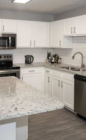 A kitchen with a granite countertop and stainless steel appliances.