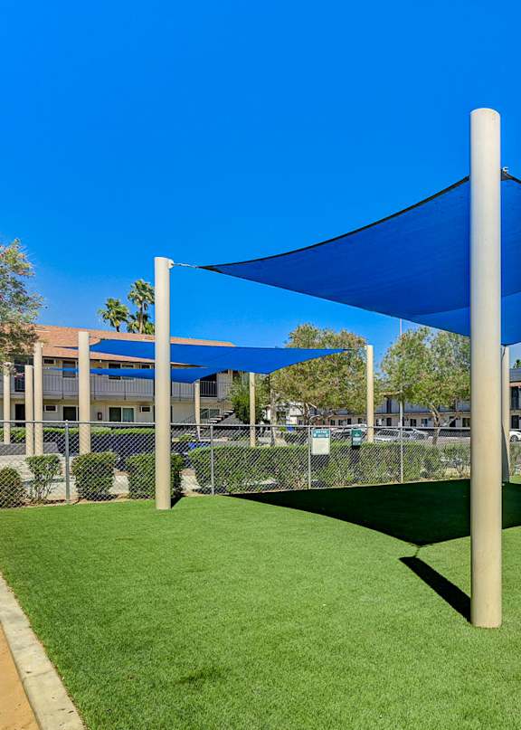 A blue shade structure is over a green area.