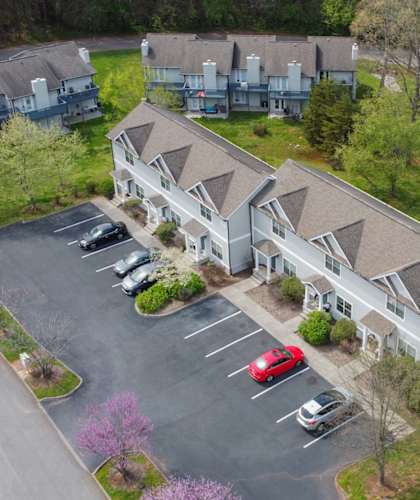 an aerial view of three buildings with cars parked in front of them