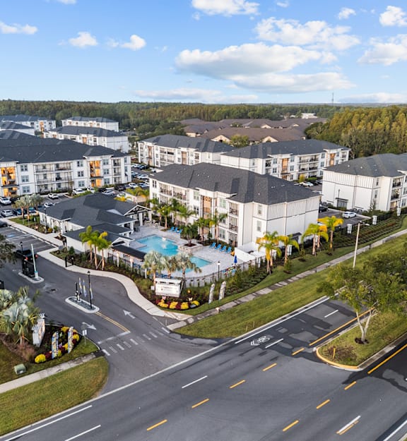 Aerial view of luxury apartment community with pool, clubhouse, and landscaped grounds.