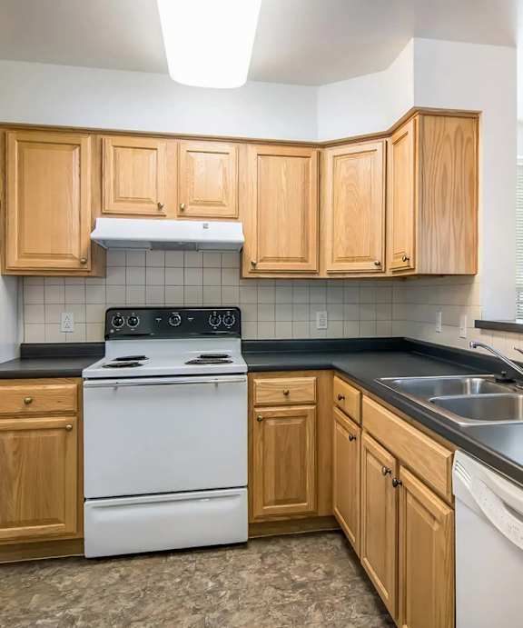 a kitchen with wood cabinets at Bedford hill apartments and townhomes in Pittsburgh, PA