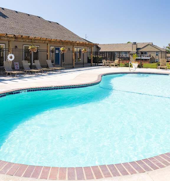 The exterior of the Cedar Crest Apartments clubhouse, featuring a well-maintained entrance and surrounding landscaping.