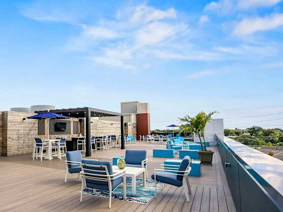 A patio with blue chairs and a table with a blue umbrella.