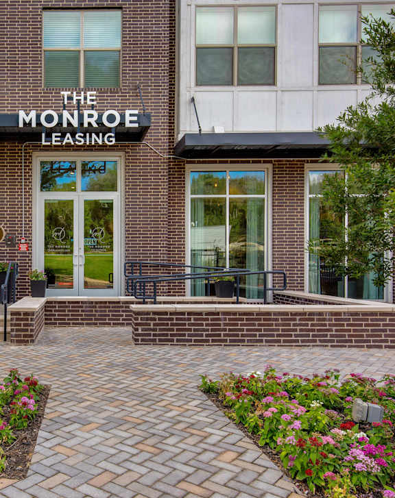 The Monroe Leasing building has a brick facade and a red fire hydrant in front.