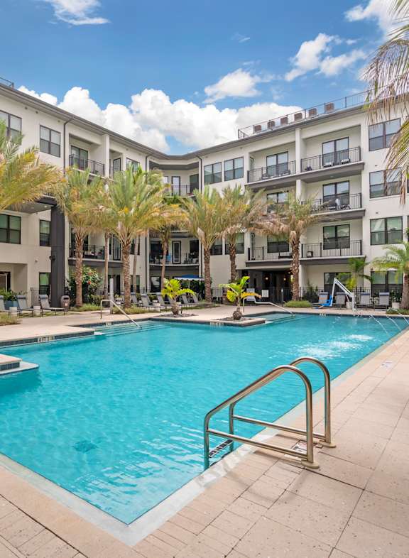 an aerial view of a large apartment complex with a sunset in the background at The District at Rosemary, Florida