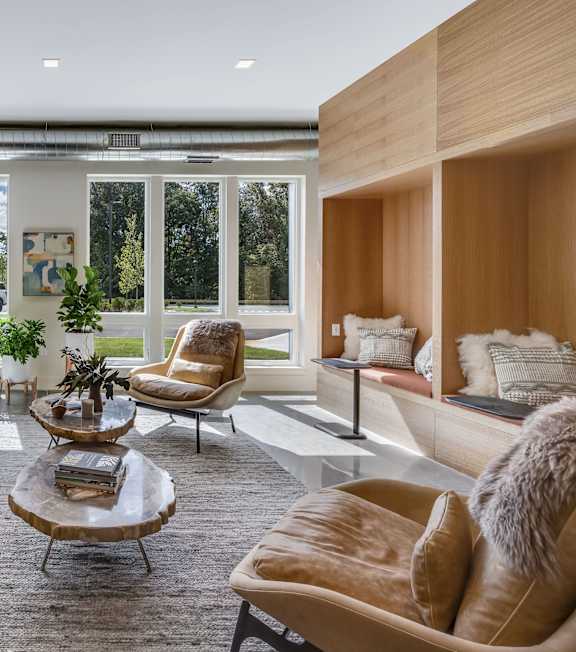 A modern living room with a large sofa, armchairs, and a coffee table.