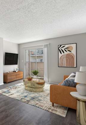 A living room with a brown couch, a white side table, and a rug.