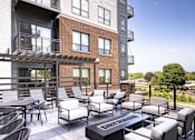 Thumbnail 28 of 28 - A patio with a table and chairs is in front of a brick building.