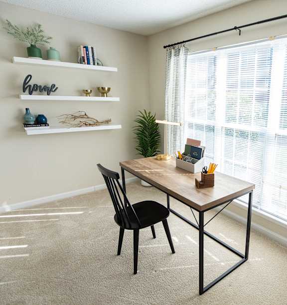 A dining room with a table, chairs, and shelves with decorative items.
