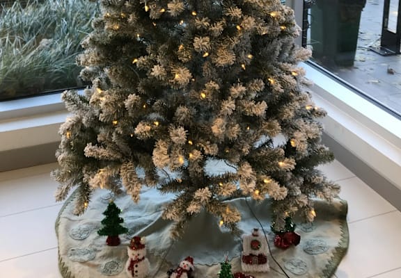 a white christmas tree on a table with snowmen and other christmas decorations