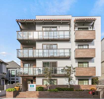 a white apartment building with balconies on the side of a street