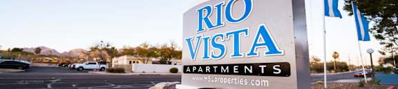 A sign for Rio Vista Apartments is displayed in front of a parking lot.