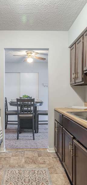 A kitchen with wooden cabinets and a white stove top oven.